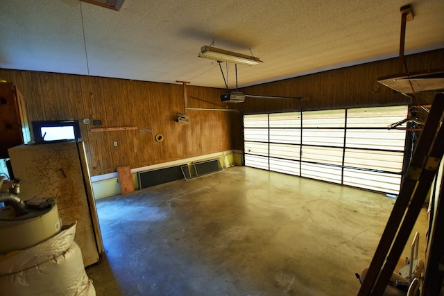 garage with wood walls and a garage door opener