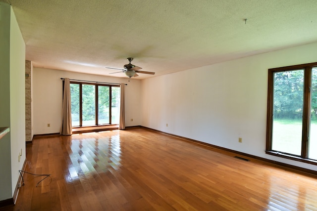 unfurnished room with a textured ceiling, light hardwood / wood-style flooring, and ceiling fan