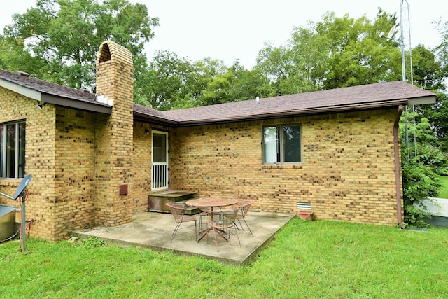 back of house with a lawn and a patio