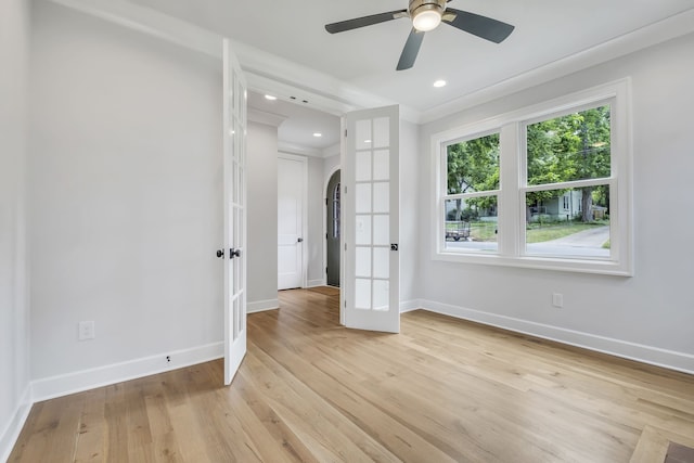 unfurnished room with ceiling fan, light wood-type flooring, and french doors