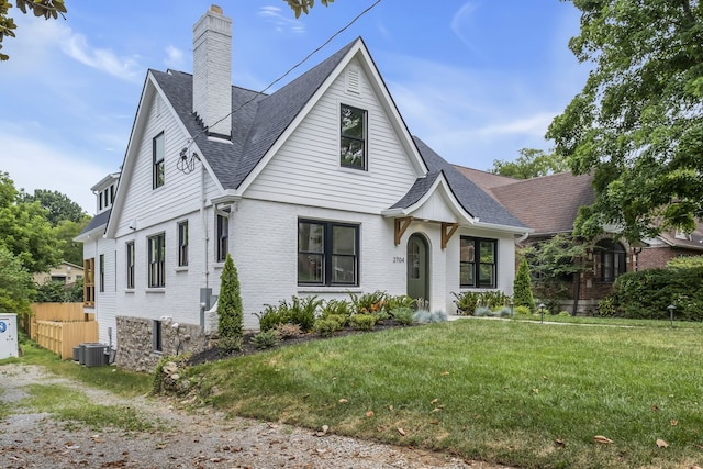 view of front of home with a front yard and central AC