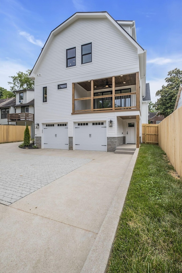 2704 Westwood Ave, Nashville, TN 37212 - back of property with stone siding, a garage, fence, a balcony, and driveway