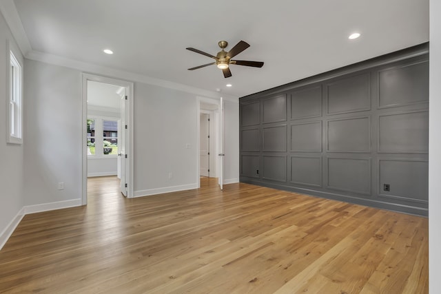 interior space featuring light wood-type flooring, ornamental molding, and ceiling fan