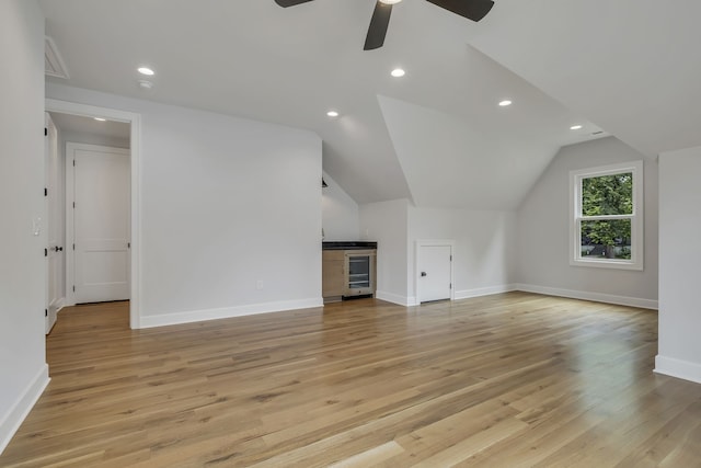 additional living space with vaulted ceiling, light hardwood / wood-style flooring, and ceiling fan