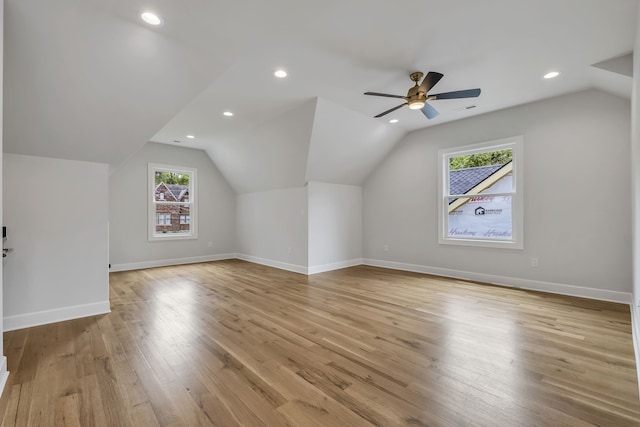 additional living space featuring vaulted ceiling, plenty of natural light, ceiling fan, and light hardwood / wood-style floors