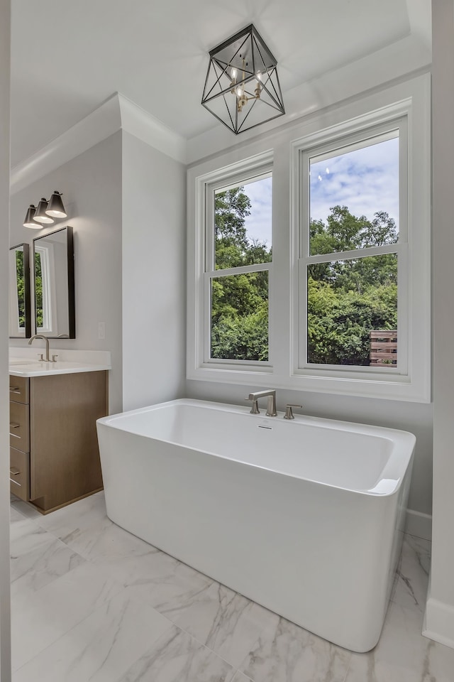 bathroom featuring a tub to relax in, plenty of natural light, a notable chandelier, and vanity