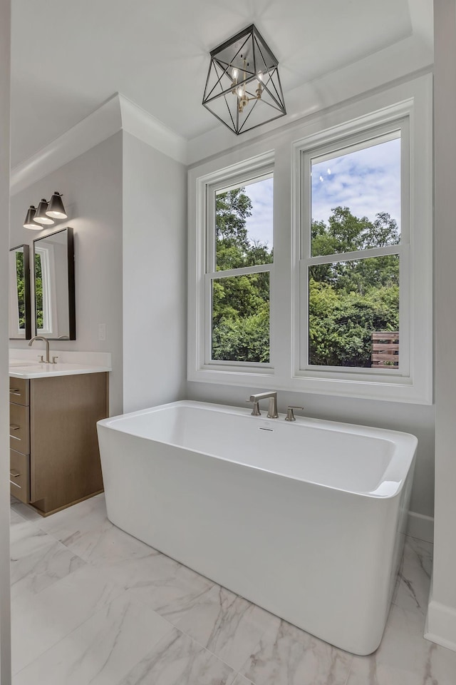 2704 Westwood Ave, Nashville, TN 37212 - bathroom featuring vanity, an inviting chandelier, ornamental molding, a soaking tub, and marble finish floor
