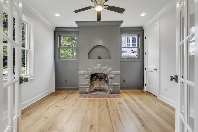 unfurnished living room with french doors, plenty of natural light, ceiling fan, and light hardwood / wood-style floors