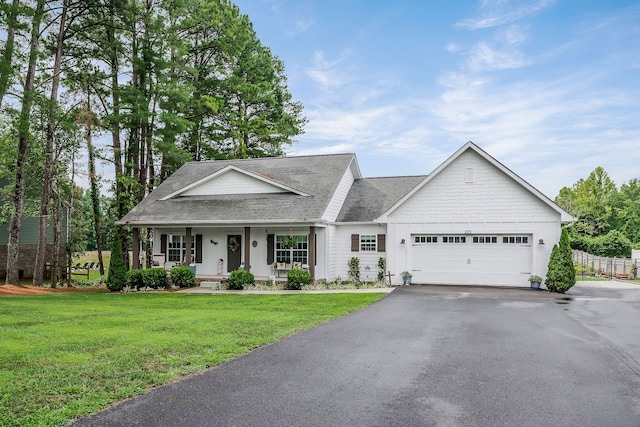 view of front of home with a front lawn, a garage, and covered porch