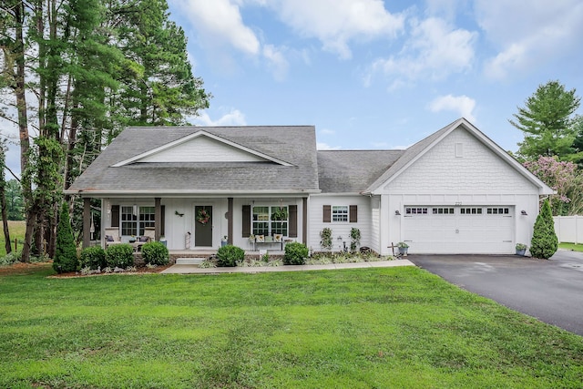 view of front of home with a garage, a front yard, and covered porch