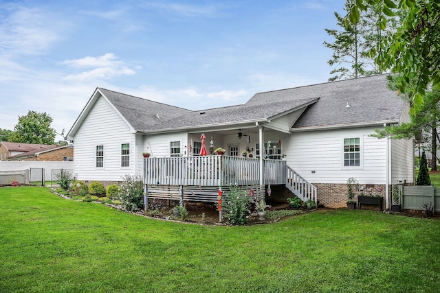 rear view of property featuring ceiling fan, a yard, and a deck