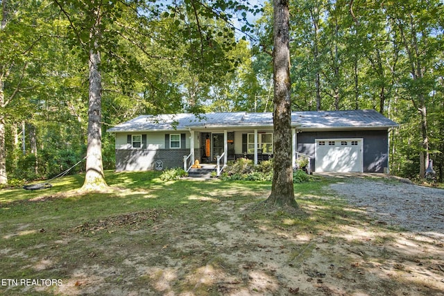 ranch-style house featuring a front yard, a garage, and covered porch