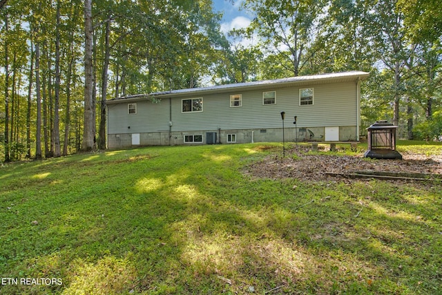 rear view of house featuring a yard and central AC