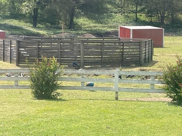view of gate with an outbuilding, fence, and a yard