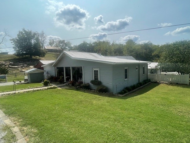 back of property with a yard, an outdoor structure, and a garage