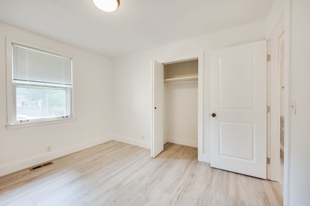 unfurnished bedroom with a closet and light hardwood / wood-style floors