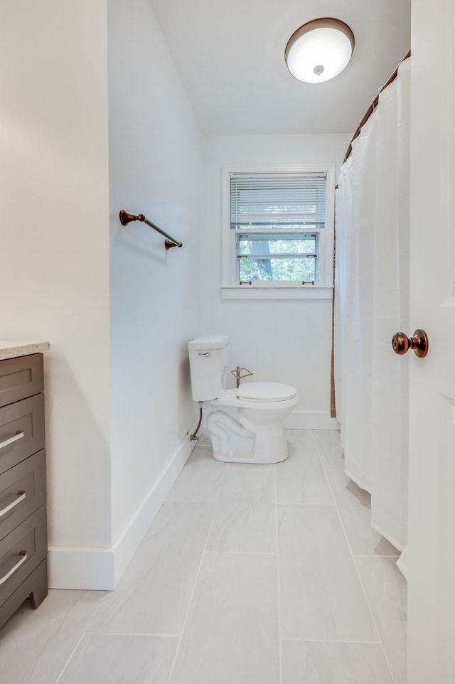 bathroom with a shower with curtain, vanity, toilet, and tile patterned floors