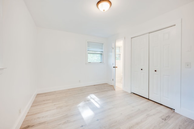 unfurnished bedroom featuring light hardwood / wood-style flooring and a closet