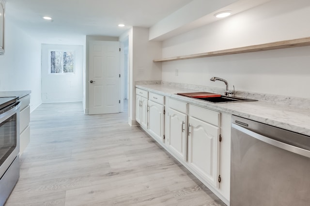 kitchen with white cabinets, appliances with stainless steel finishes, sink, and light hardwood / wood-style flooring