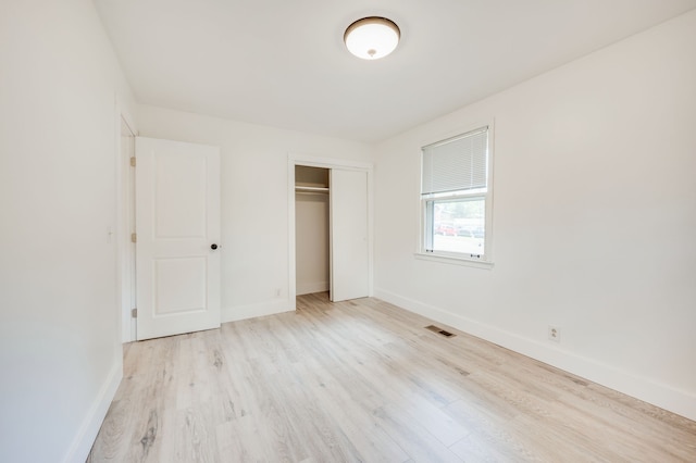 unfurnished bedroom featuring light hardwood / wood-style flooring and a closet