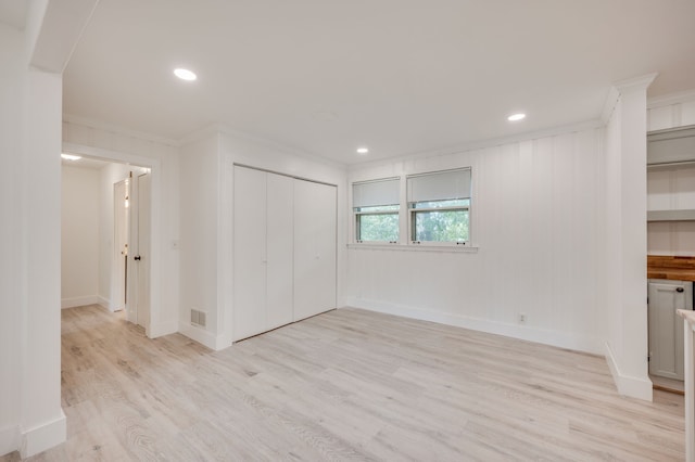 unfurnished living room with ornamental molding and light hardwood / wood-style flooring