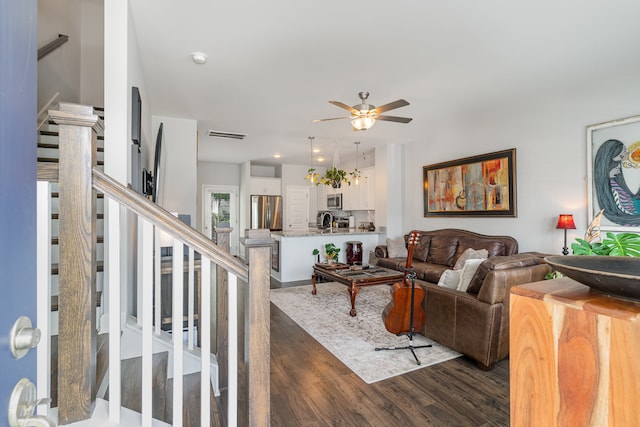 living room with ceiling fan and dark wood-type flooring