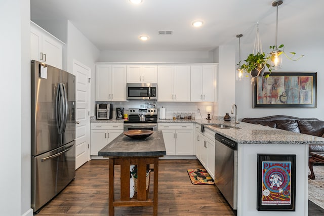 kitchen with sink, white cabinets, pendant lighting, and appliances with stainless steel finishes