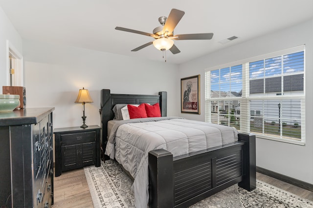 bedroom featuring multiple windows, ceiling fan, and light wood-type flooring