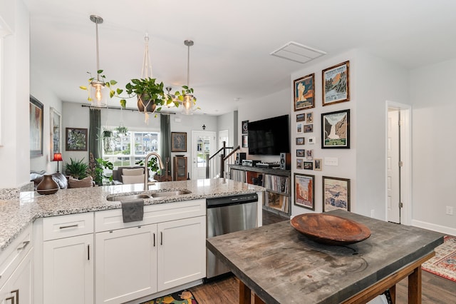 kitchen with light stone countertops, stainless steel dishwasher, sink, white cabinets, and hanging light fixtures