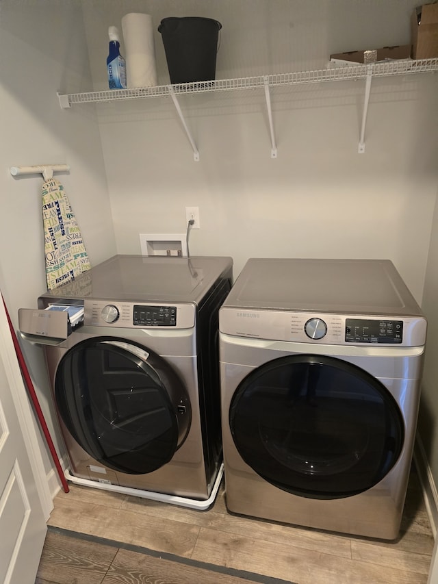 laundry area featuring wood-type flooring and separate washer and dryer