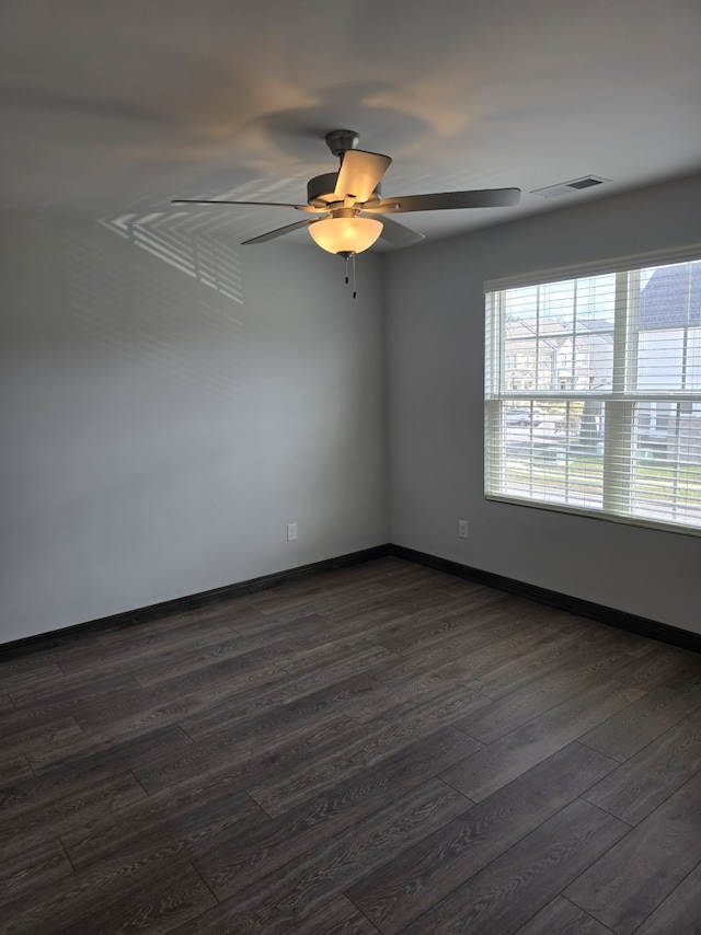 unfurnished room with ceiling fan and dark hardwood / wood-style flooring