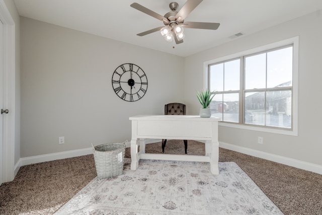 carpeted office space featuring ceiling fan