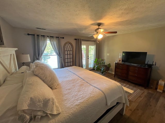 bedroom featuring access to exterior, dark hardwood / wood-style flooring, ceiling fan, and multiple windows