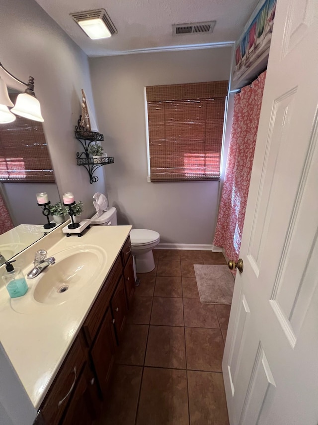 bathroom with tile patterned flooring, visible vents, toilet, and vanity