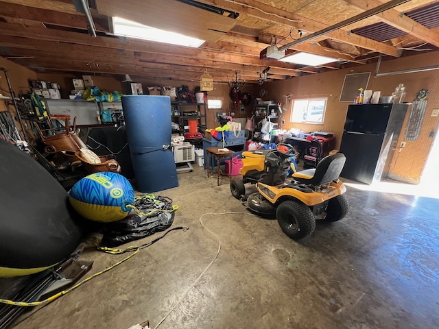 garage with black refrigerator and a workshop area