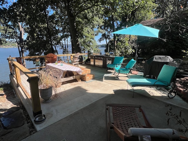 view of patio featuring a deck with water view
