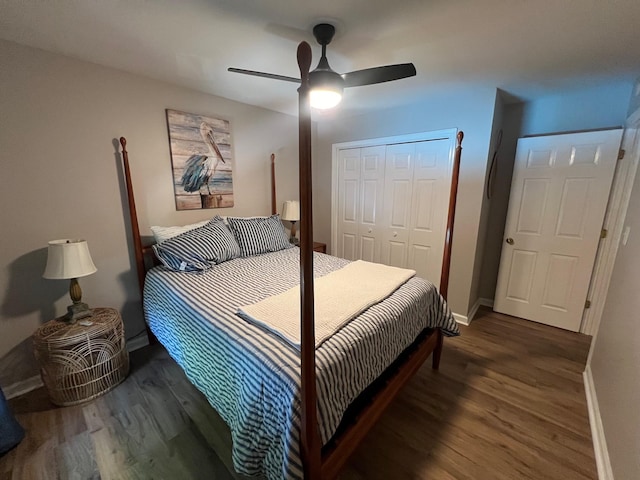 bedroom featuring a closet, baseboards, wood finished floors, and a ceiling fan