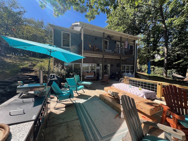 exterior space featuring ceiling fan, a patio area, and an outdoor fire pit