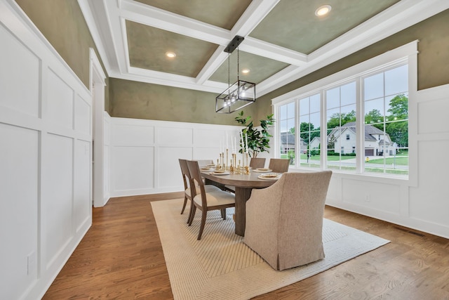 dining space featuring coffered ceiling, wood-type flooring, an inviting chandelier, and beam ceiling