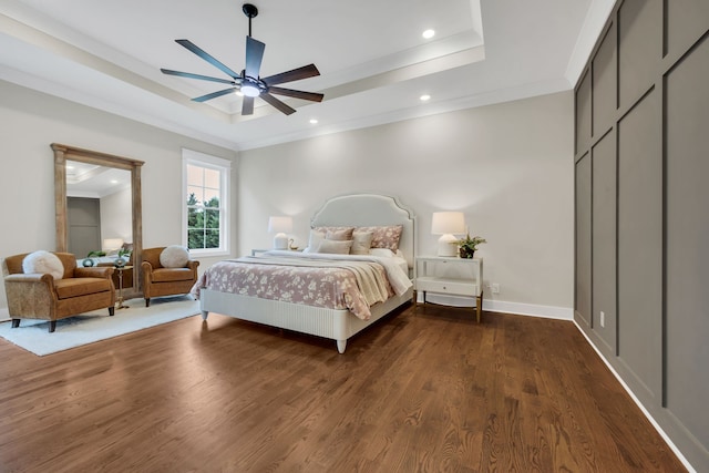 bedroom with ceiling fan, dark hardwood / wood-style floors, a raised ceiling, and crown molding