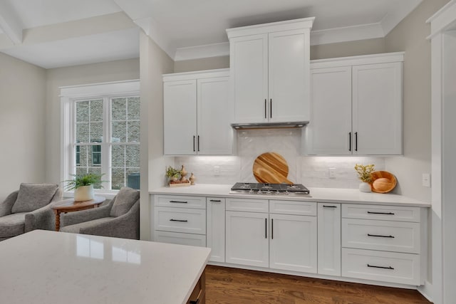 kitchen featuring dark wood-type flooring, stainless steel gas cooktop, decorative backsplash, and white cabinetry