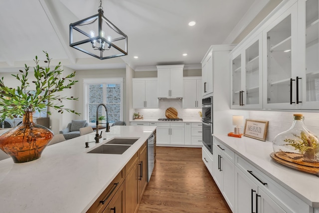 kitchen with an inviting chandelier, tasteful backsplash, dark wood-type flooring, sink, and white cabinetry