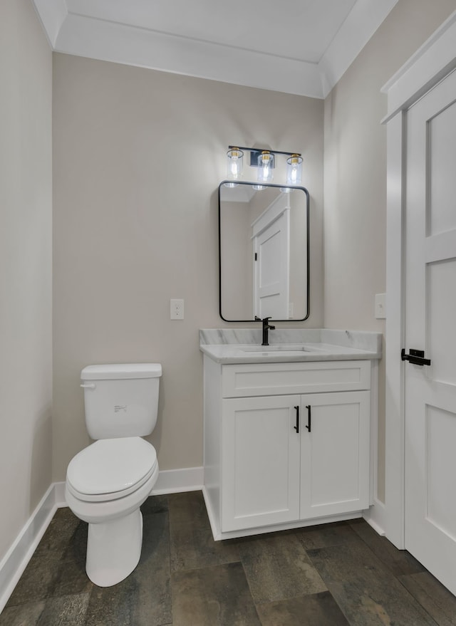 bathroom featuring vanity, toilet, and ornamental molding