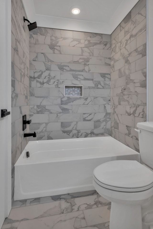 bathroom with tiled shower / bath and toilet