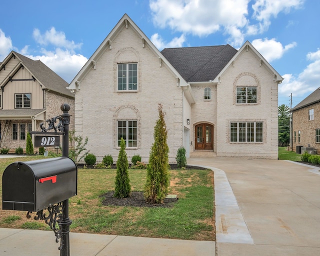 view of front of home featuring central AC and a front lawn