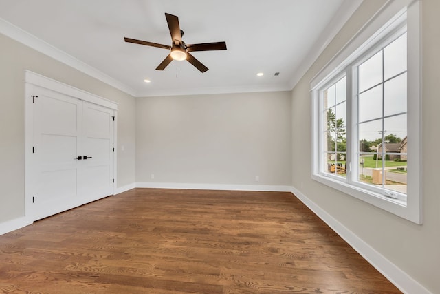 empty room featuring dark wood-type flooring, ceiling fan, and ornamental molding