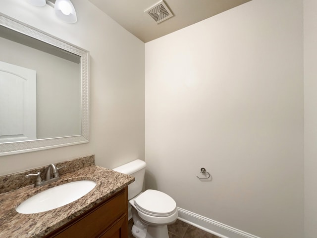 bathroom featuring tile patterned flooring, vanity, and toilet