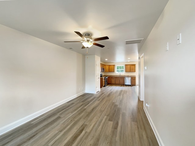 unfurnished living room with ceiling fan, hardwood / wood-style floors, and sink