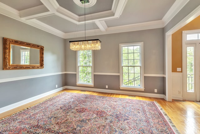 unfurnished room with light hardwood / wood-style floors, crown molding, coffered ceiling, and a healthy amount of sunlight