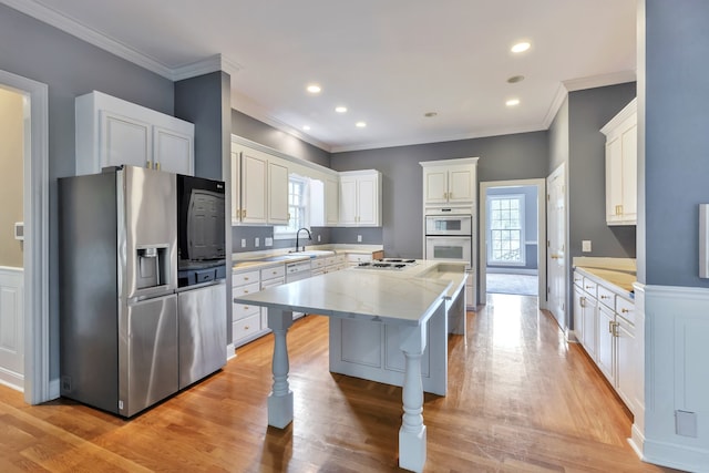 kitchen with stainless steel appliances, a wealth of natural light, sink, and a center island